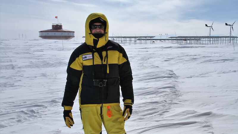 Kim Ellis standing on the ice with China’s Taishan station in the background.