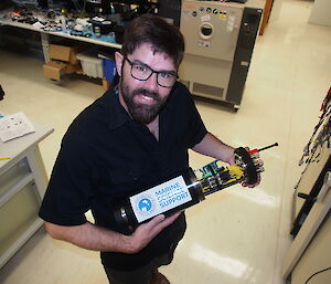 Mark Milnes holds the test device for Nuyina’s fibre optic and electrical cables.
