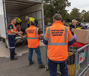 Australian Antarctic Division staff helping Hobart City Mission workers load clothing into the back of a truck