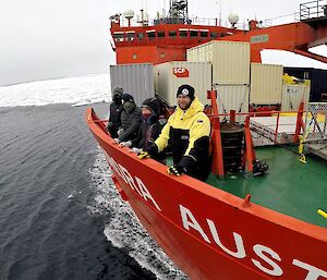 A group of expeditioners standing at bow of icebreaker Aurora Australis