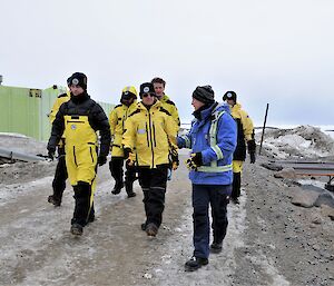 group of people walk around station