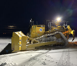 A dozer working at night moving snow