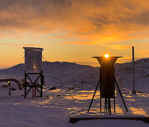 The sun setting into the snow gauge