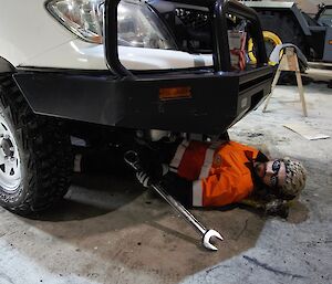 Field training officer in the vehicle workshop, lying under a vehicle