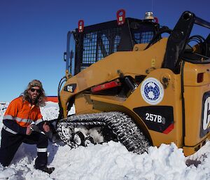 Expeditioner with a bogged tracked vehicle in the snow