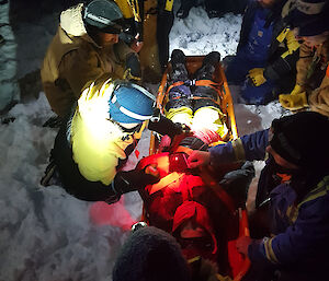 Casualty Jason is secured into the orange stretcher by a hoard of rescuers in the dark, snowy morning