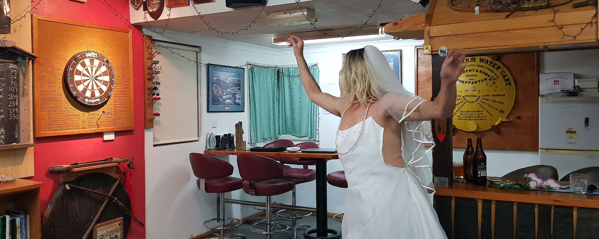 a man wearing a wedding dress plays darts