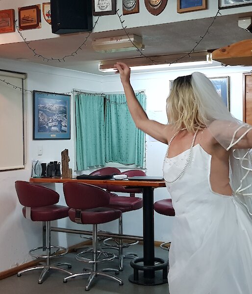 a man wearing a wedding dress plays darts