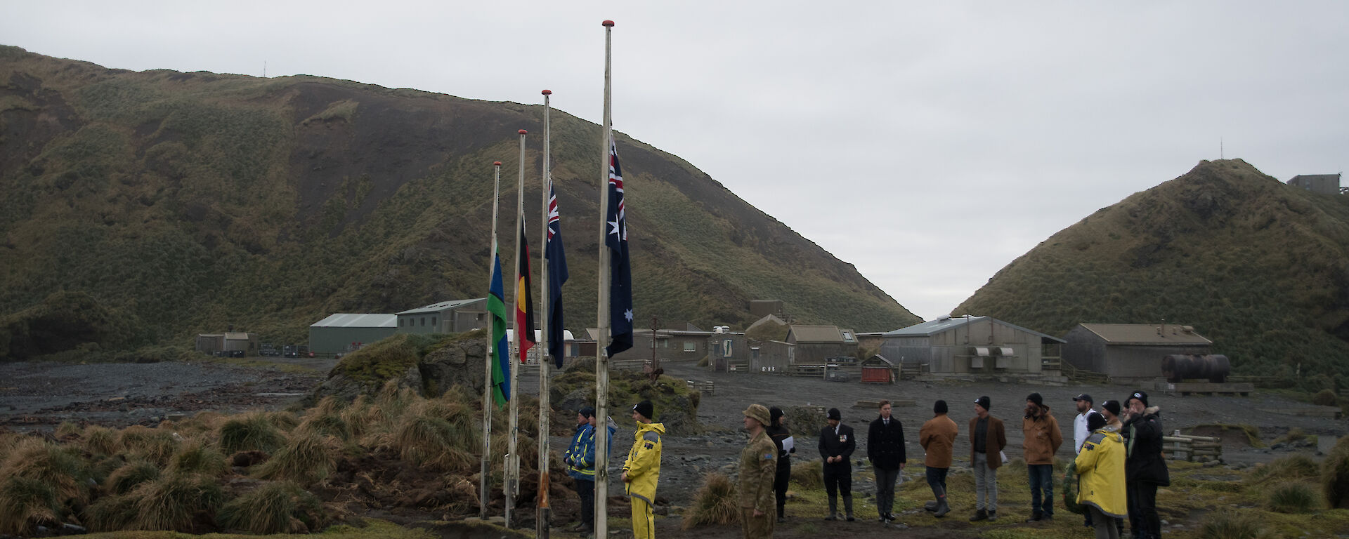 Group of expeditioners gathered around flag poles