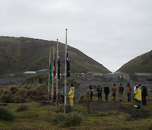 Group of expeditioners gathered around flag poles