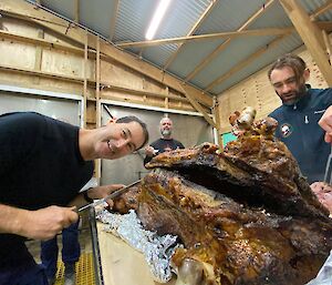 Two men carving roast lamb