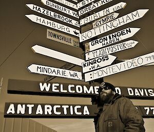 An expeditioner in front of a sign post