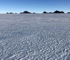 Landscape of ice and a mountain range in the distance