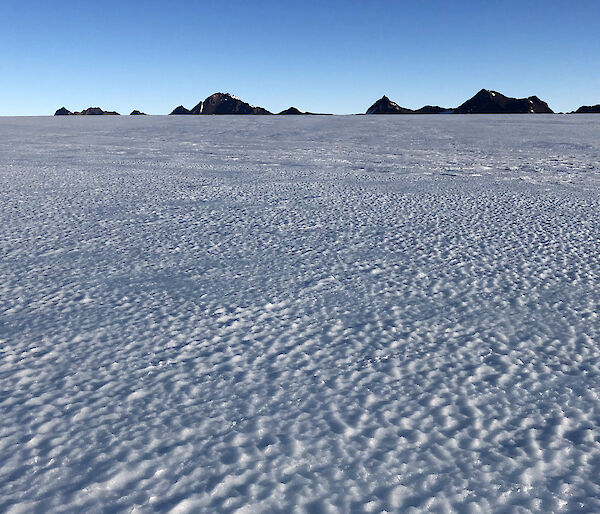 Landscape of ice and a mountain range in the distance