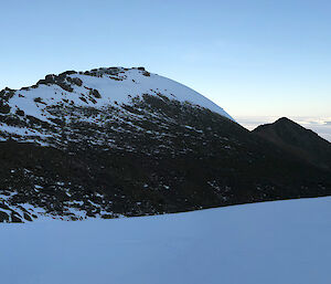 Panorama of snow covered mountains and a field hut