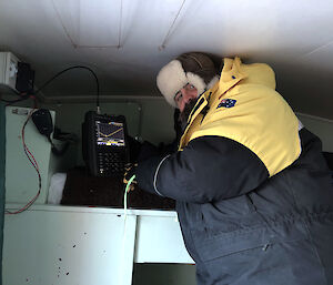 A communications officer testing the hut radio