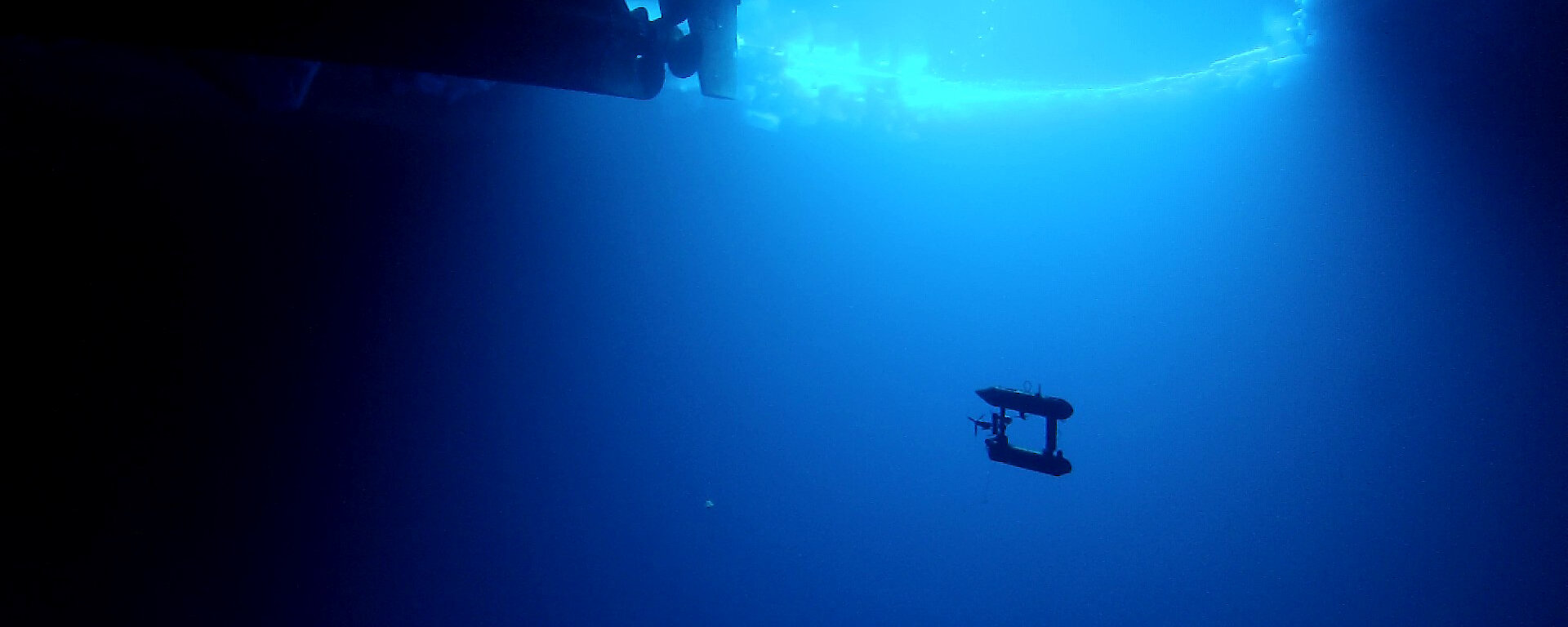 AUV underwater with ship visible above.