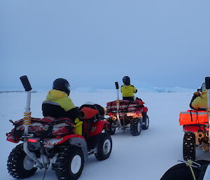 the expeditioners on their red quad bikes among a white, frozen sea of icebergs