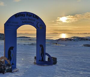 The arch that was made on station as the start and finish line for Relay For Life as the sun is setting in the west