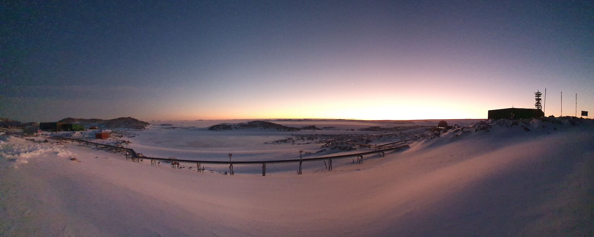 Panoramic view of the sun rising over the ice