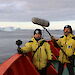 John McCormick holds a 360 degree camera and Adam Nash holds a boom microphone, on the deck of the Aurora Australis in Antarctica.