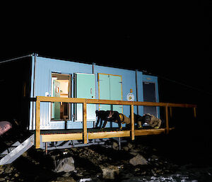 Two expeditioners doing push ups on the deck of a field hut