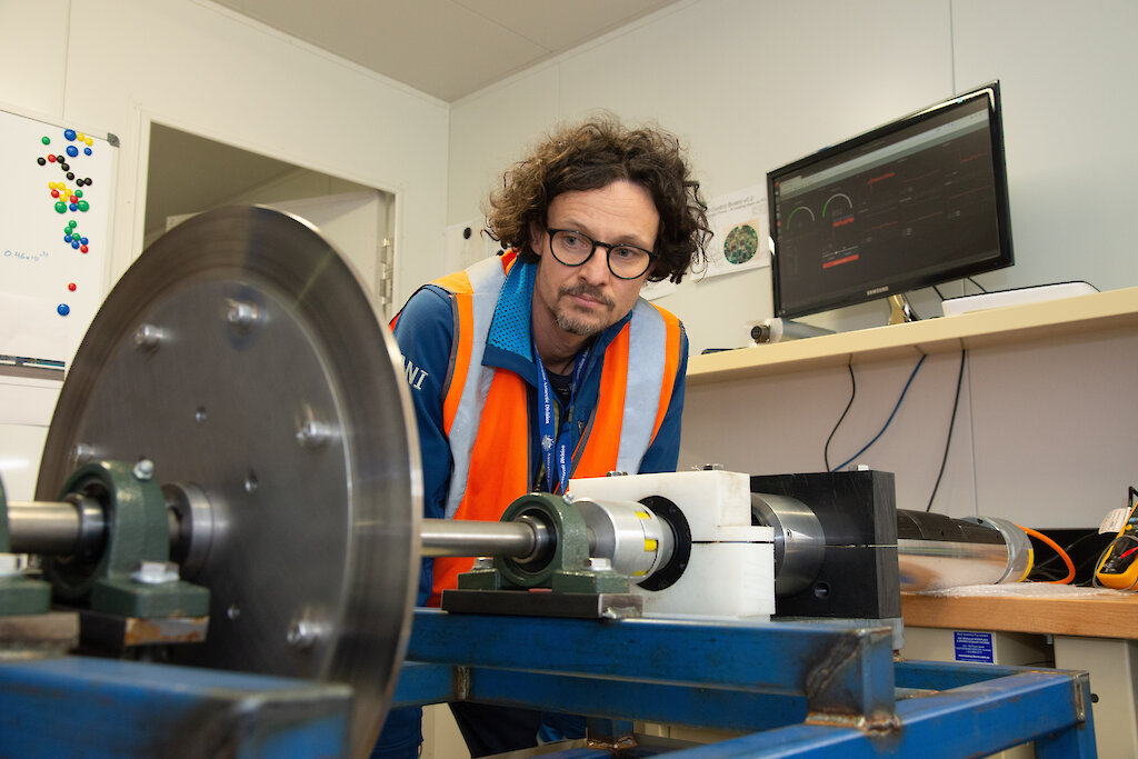 An engineer looks at the ice core drill rig.