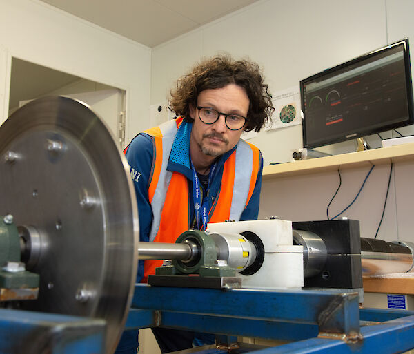 An engineer looks at the ice core drill rig.