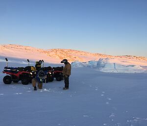 Two expeditioners drilling through the sea ice