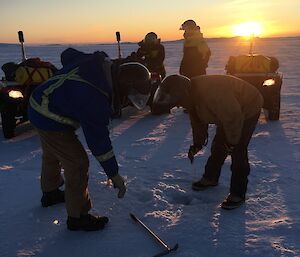 Two expeditioners taking thickness measurements in the sea ice