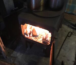 The wood fired stove alight in the field hut