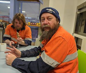 The station electrician sitting at a table in the mess