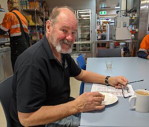 Station plumber sitting at the table eating breakfast