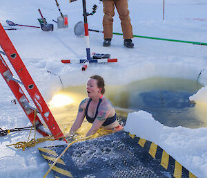 Davis station chef, Donna Wightman, lowers herself through a hole in the sea ice for a dip in the Davis ‘swimming pool’.