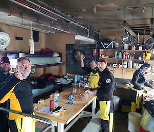 A group of expeditioners inside a field hut