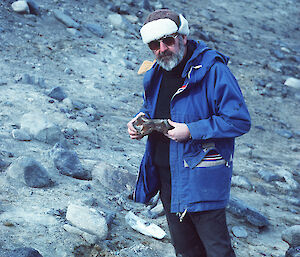 Scientist standing and inspecting fossil find