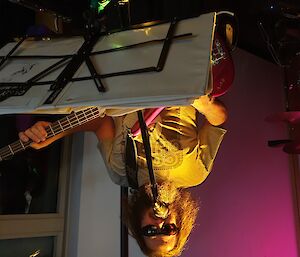 Musician playing guitar on stage at Casey research station.