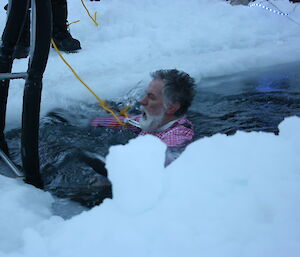Expeditioner wearing colourful shirt taking a dip in the Casey sea ice swimming pool.