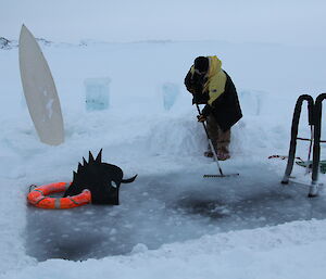 The sea ice pool being raked by an expeditioner in preparation for the Midwinter swim.