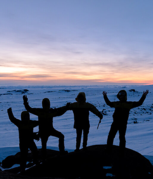 Photo of a group silhouetted up on a rocky outcrop