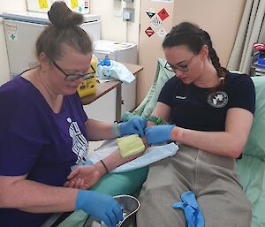 A weather observer, the phlebotomist, taking blood from the doctor in a medical scenario