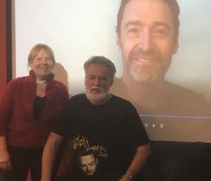 Station Leader and Chef in the bar at Casey in front of the movie screen which is playing Hugh Jackman's personal video reply to their Midwinters invitation.