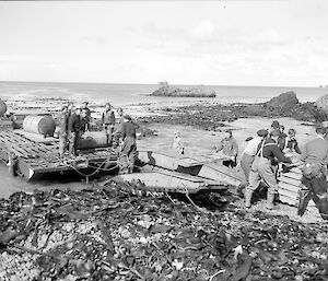 Historical photo of the water tanks coming off a barge onto the beach