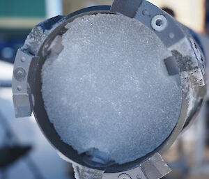 A circle of ice inside a metal drill.