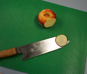 A knife made at Casey with an apple that it has cut