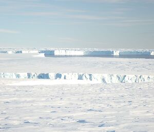 A view of the large tabular bergs frozen in the sea ice from Browning Peninsula near Casey