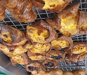 Golden brown pastries, and bagels rest on a cooling rack before brunch service