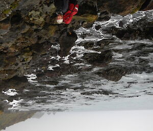 An expeditioner on a rocky beach