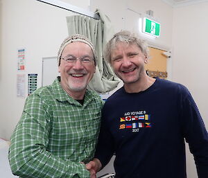 A smiling Doctor and plumber shake hands