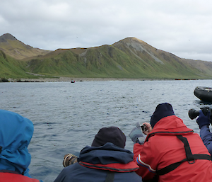 Tourist ship with inflatable rubber boats with multiple photographers taking photos of the bay